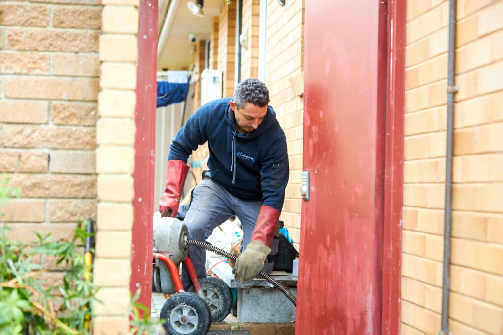 plumber using jet rodding to unblocking a drain in Canberra