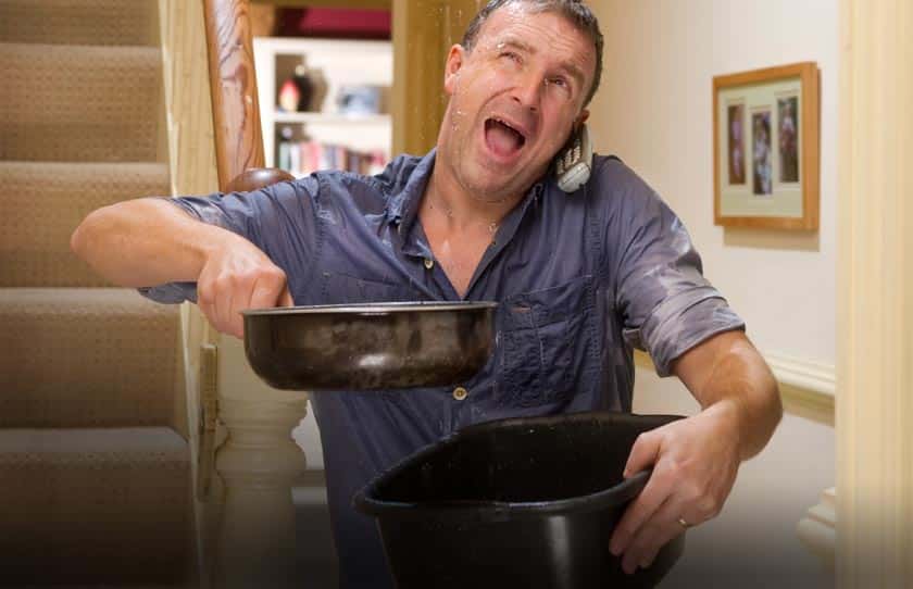 leaking plumbing, man holding pans and calling plumber