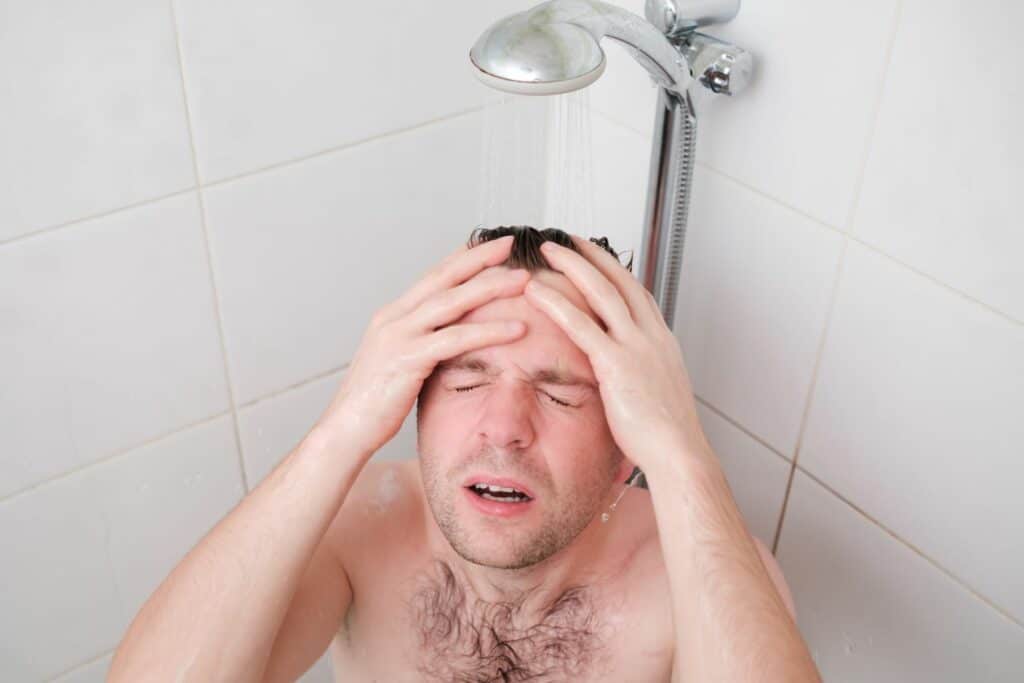 man having hot water issues in shower