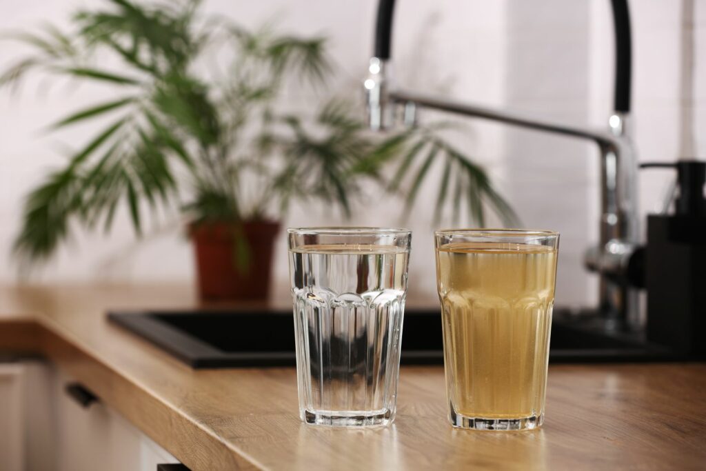 examples of water filtration, dirty and clean water in glasses on bench